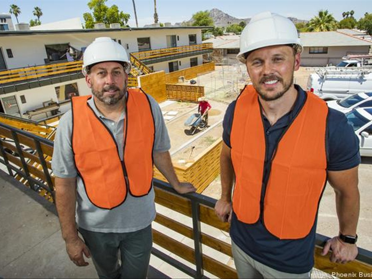 Two men in hard hats and safety vests overlooking a Neighborhood Ventures apartment renovation, photographed for the Phoenix Business Journal